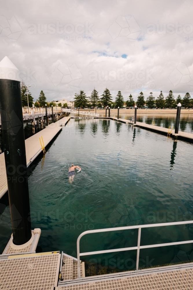 ocean swimming pool with one anonymous swimmer - Australian Stock Image