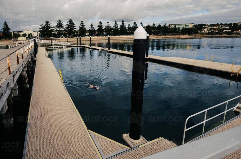 outdoor sea pool with one anonymous swimmer - Australian Stock Image