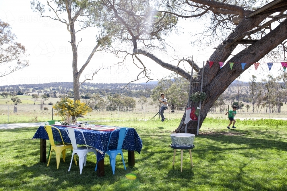 Outdoor table setting for Christmas celebration in country backyard - Australian Stock Image