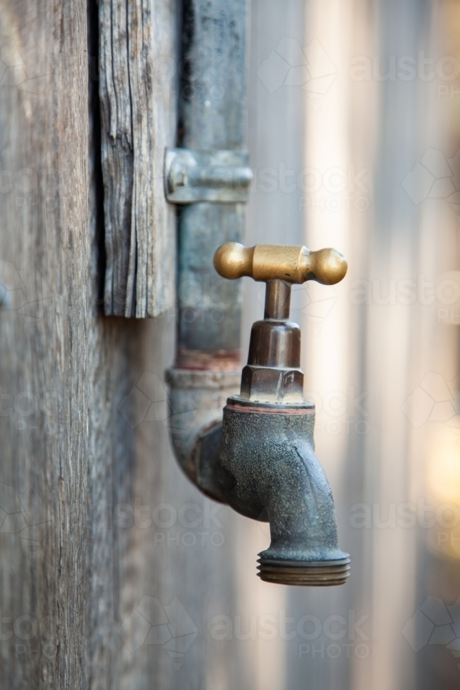 Outside tap on side of wooden building - Australian Stock Image