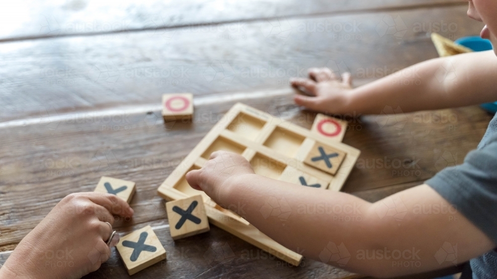 Over the shoulder shot of childs hands doing puzzle - Australian Stock Image