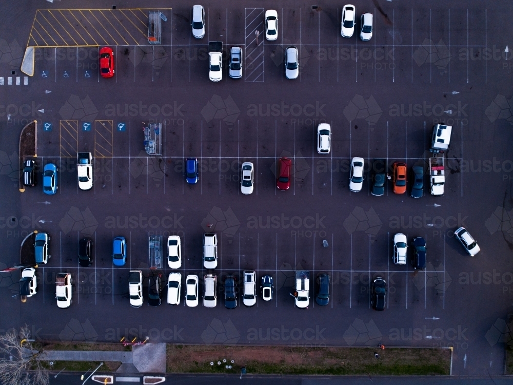 Overhead aerial view of cars parked in bays in half empty car park - Australian Stock Image
