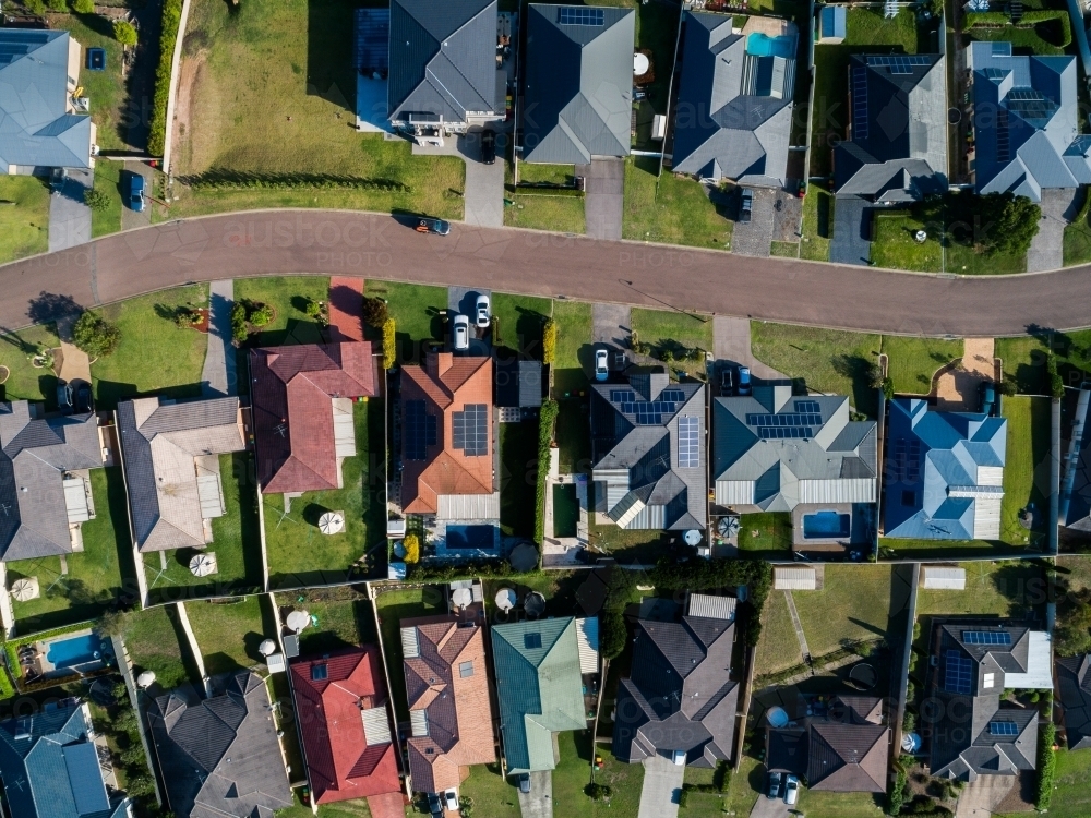 Overhead aerial view of houses along a street in sunlight - Australian Stock Image