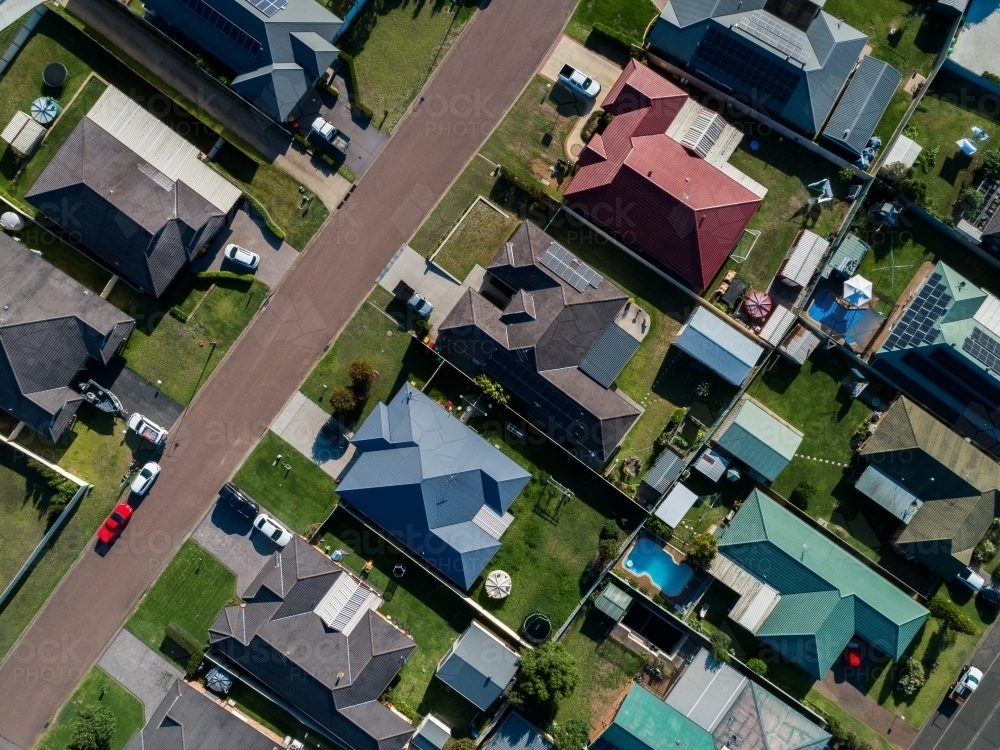 Overhead aerial view of houses along a street in sunlight - Australian Stock Image