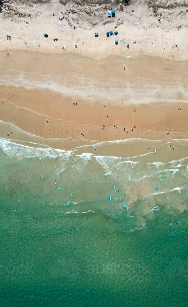 Overhead aerial view of young surfers learning to surf on australian beach - Australian Stock Image
