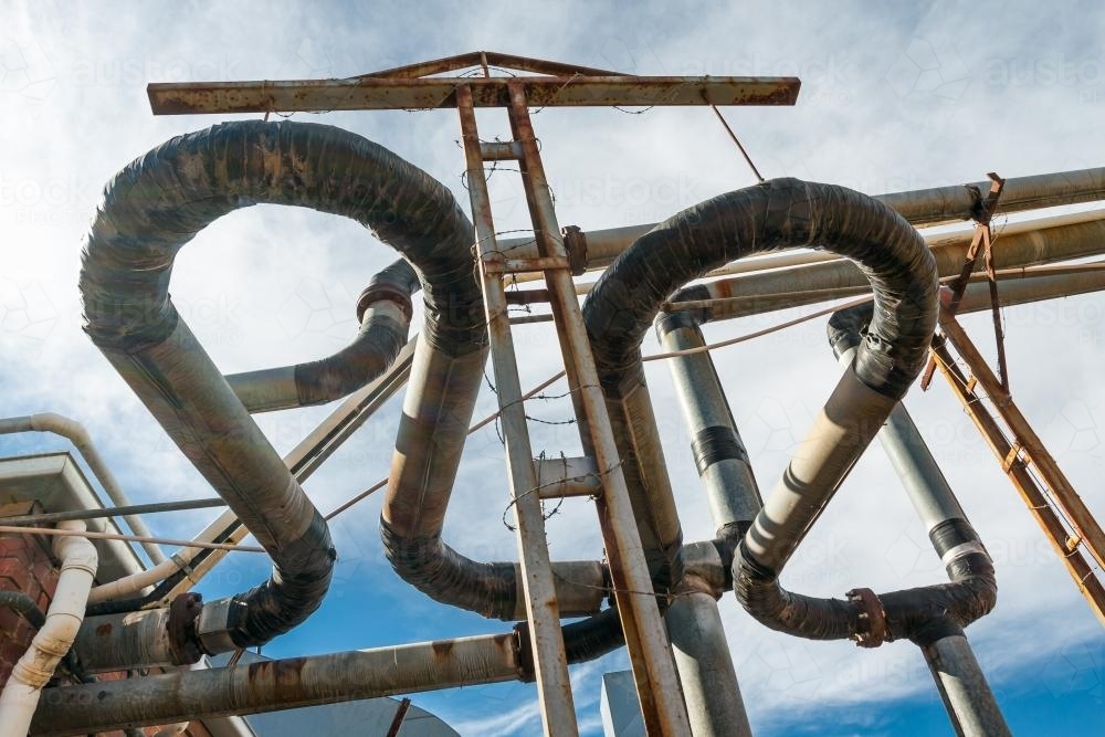 Image of Overhead industrial pipes - Austockphoto