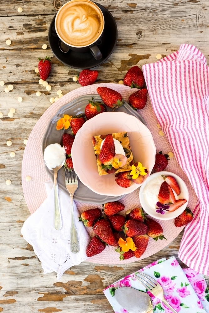 overhead of strawberry dessert with a flat white coffee - Australian Stock Image