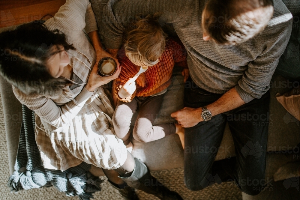 Overhead shot of family with young boy together on couch at home - Australian Stock Image