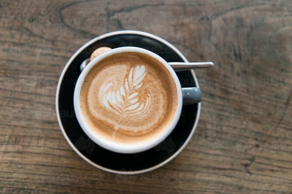Overhead view of a coffee on a wooden table - Australian Stock Image