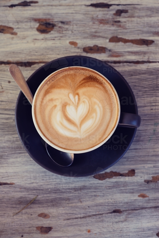 overhead view of a flat white coffee with a love heart shape in the crema - Australian Stock Image