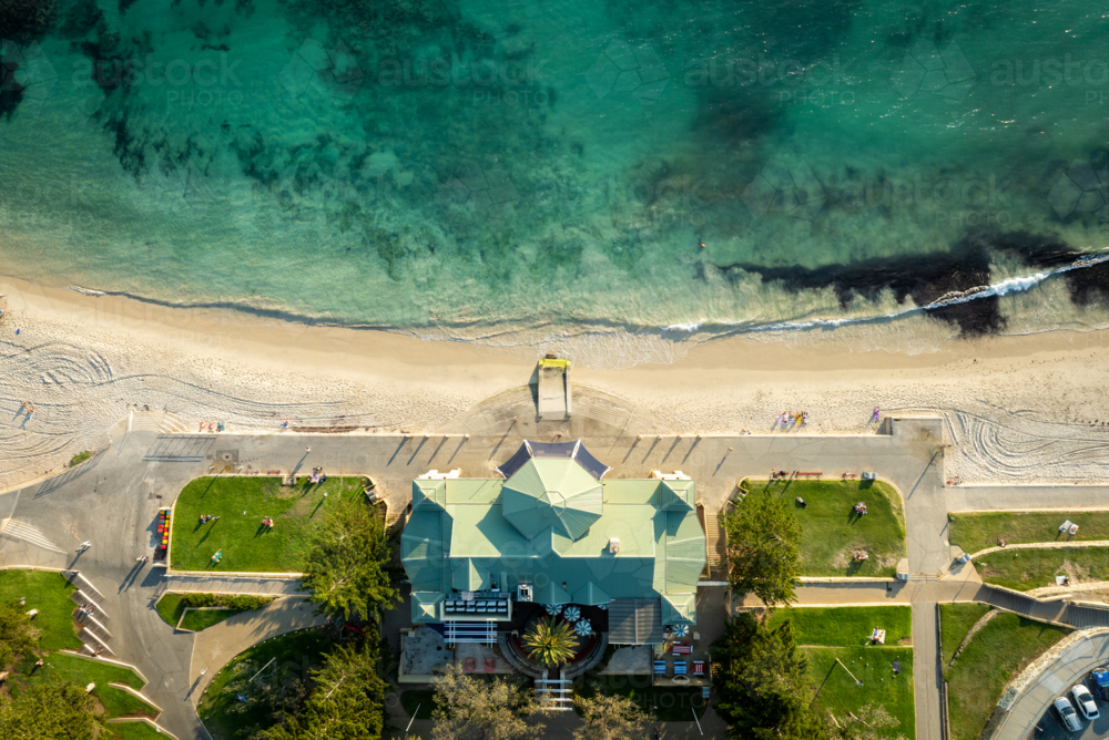 Overhead view of a green-roofed building and lawns next to a white sand beach. - Australian Stock Image