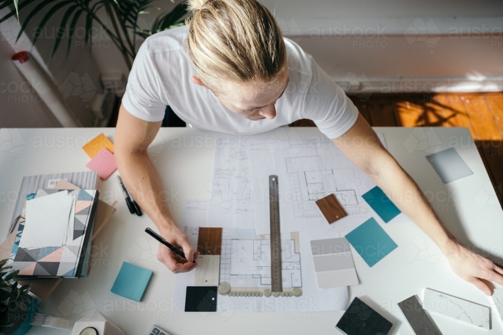 Overhead view of a young architect working at his desk - Australian Stock Image