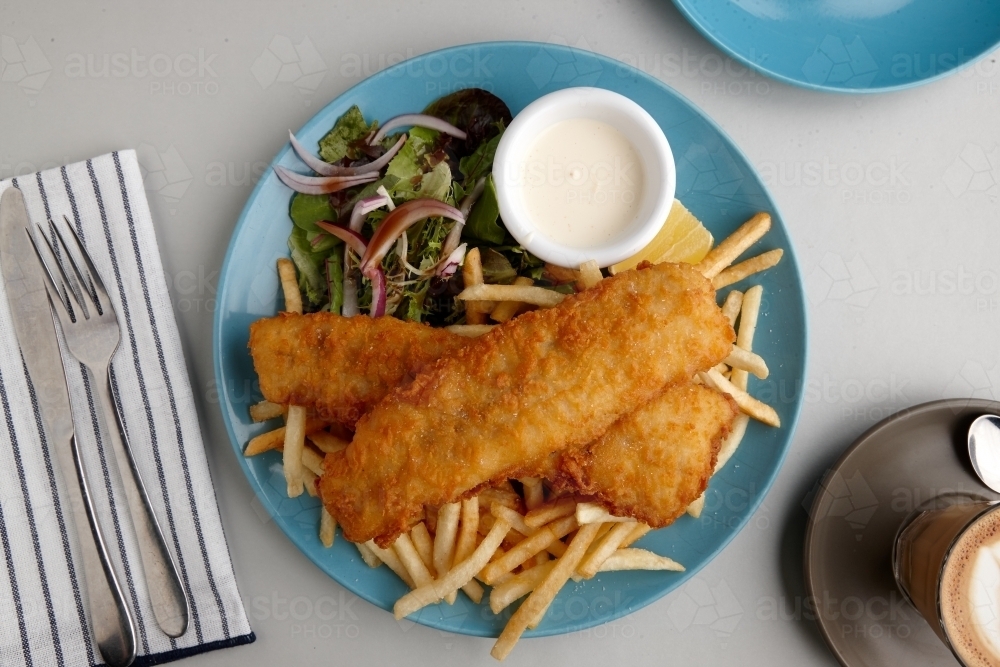 Overhead view of battered fish and chips on table - Australian Stock Image