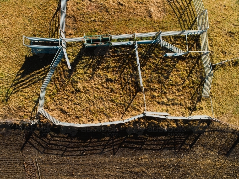 Overhead view of cattle yards beside tilled farm land - Australian Stock Image