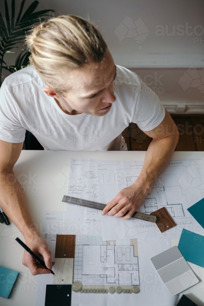 Overhead view of desktop and architect at work - Australian Stock Image