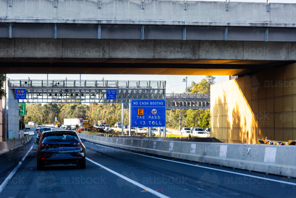 overpass before toll road toll point with no cash booth sign e-tag e-pass signage - Australian Stock Image