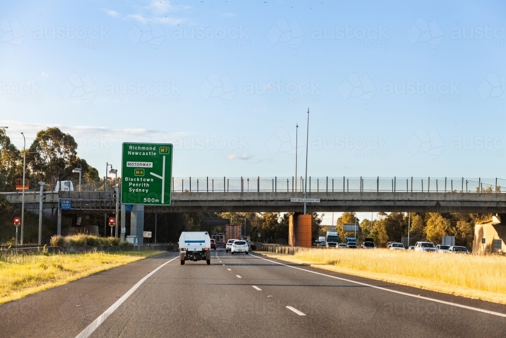 overpass bridge over road with cars driving on divided highway - Australian Stock Image