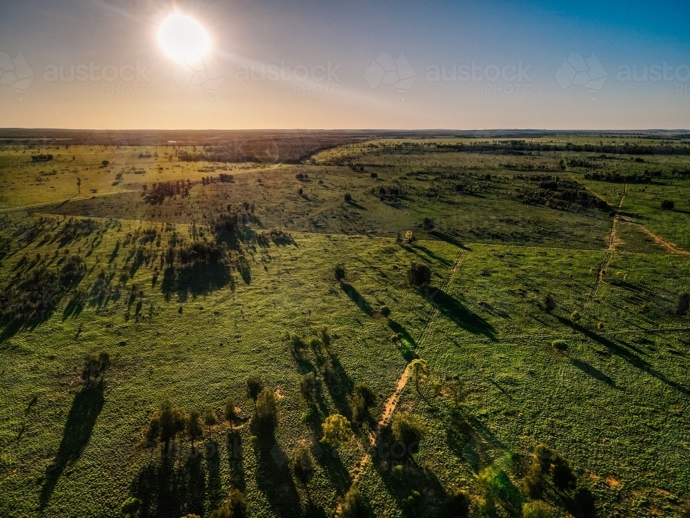 Overview of varying green paddocks facing into the sun - Australian Stock Image