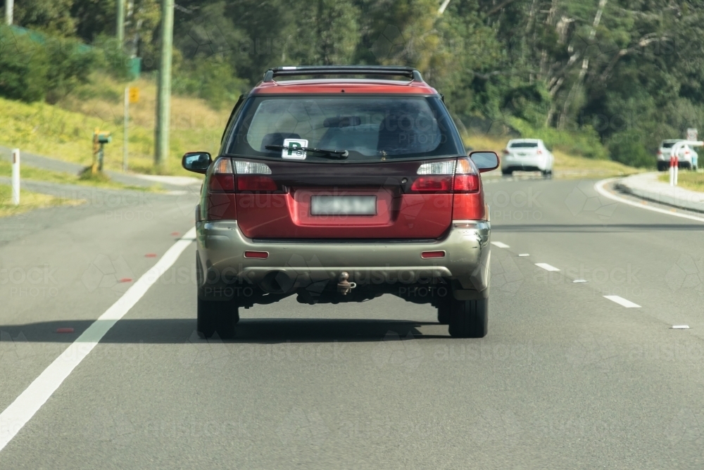 P Plater driving on sealed road in suburban area - Australian Stock Image