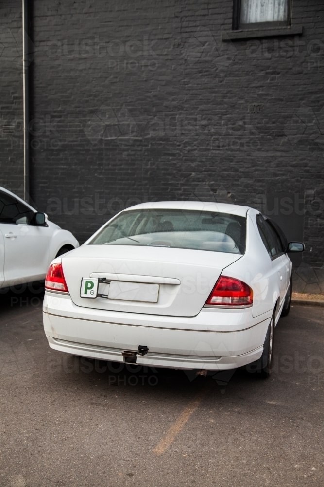 P2 plate car parked over line in car park - Australian Stock Image