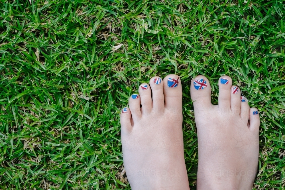 painted patriotic toenails on the grass, union jack for UK, Australia or NZ. - Australian Stock Image