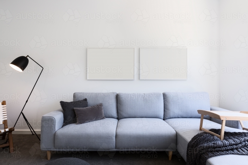 Pale blue linen sofa and blank pictures in a living room - Australian Stock Image