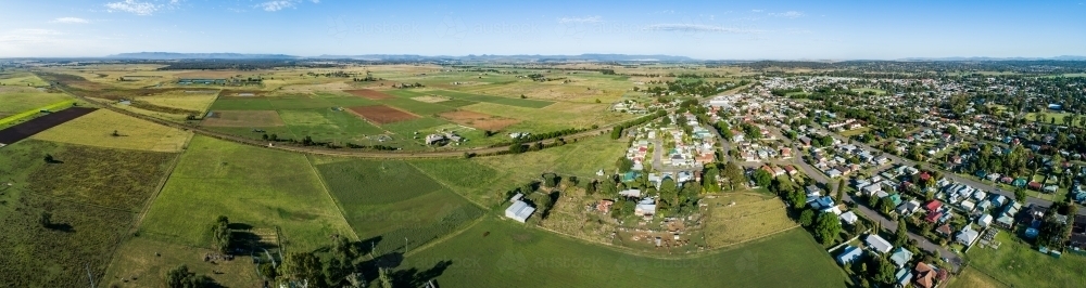 Panorama of edge of town with railway train line through paddocks and homes - Australian Stock Image