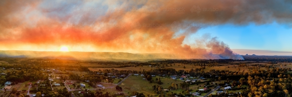 Panorama of fields and town at sunset with dramatic sky of bushfire smoke - Australian Stock Image