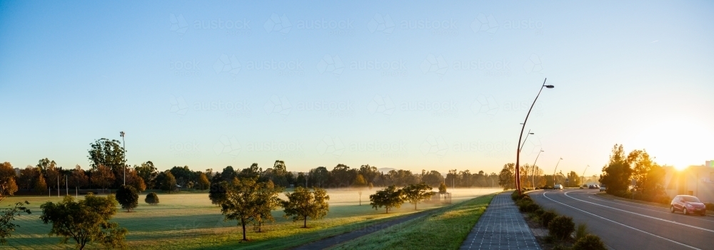panorama of misty playing fields and road in morning light in Singleton - Australian Stock Image