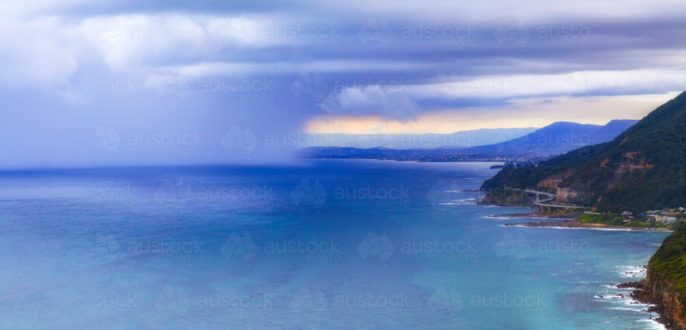 Panorama view of a rain squall approaching the Illawarra Coast including Sea Cliff Bridge. - Australian Stock Image