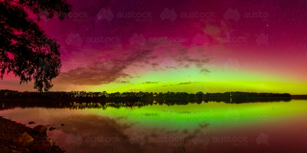 Panorama view of colourful Aurora Australias reflected on an inland lake - Australian Stock Image