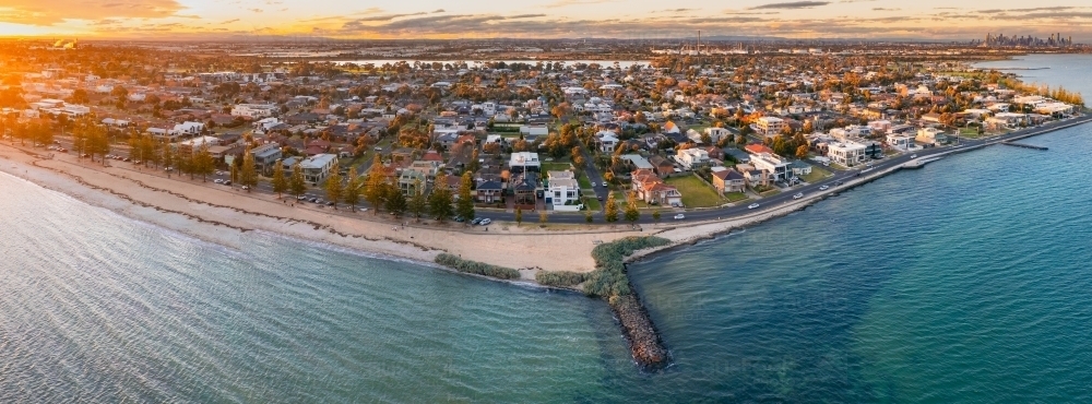 Panoramic aerial view of bay side suburb and beach at sunset - Australian Stock Image