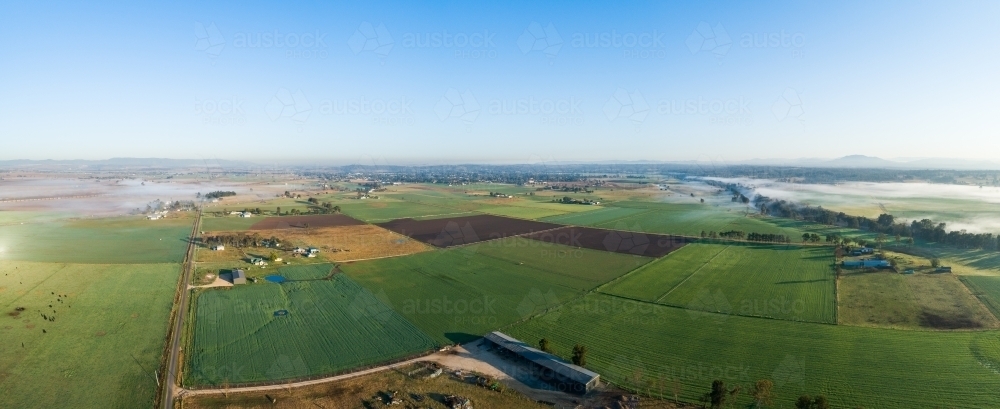 Panoramic landscape of farmland in Hunter valley with light mist on horizon - Australian Stock Image