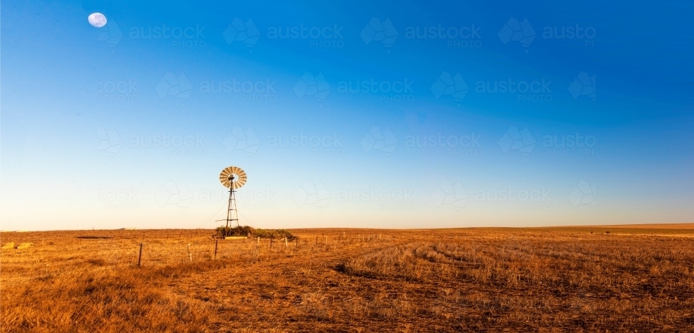 Panoramic view of early morning landscape with a windmill. - Australian Stock Image