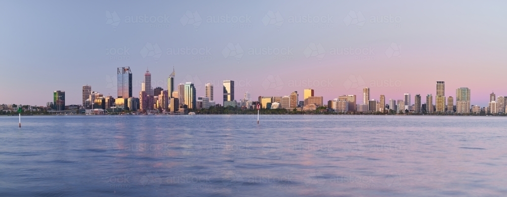 Panoramic view of the Perth skyline across the Swan River at dusk. - Australian Stock Image