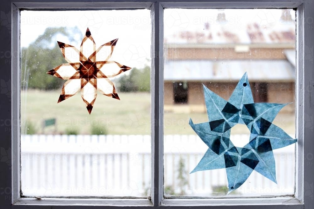 Paper stars stuck to window inside a farm house - Australian Stock Image