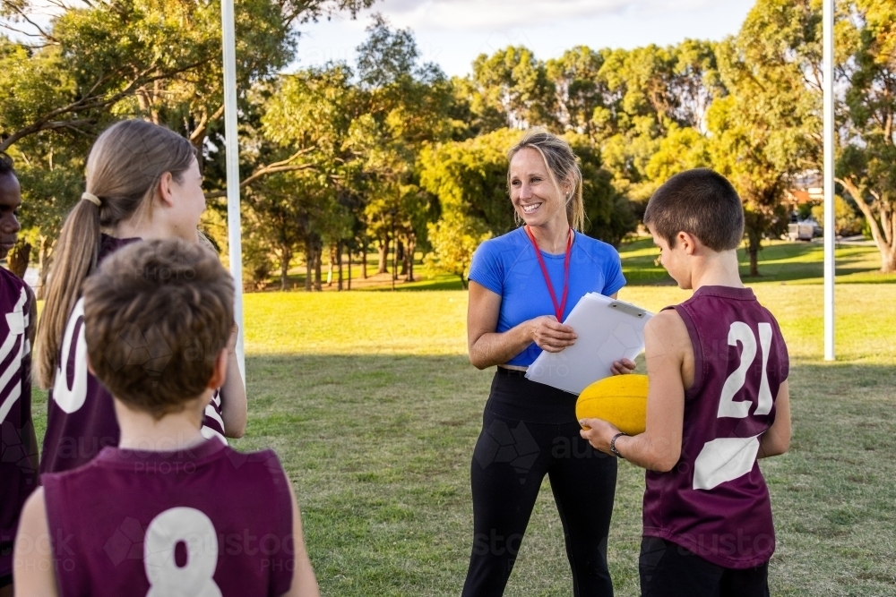 parent volunteer coaching kids football team - Australian Stock Image