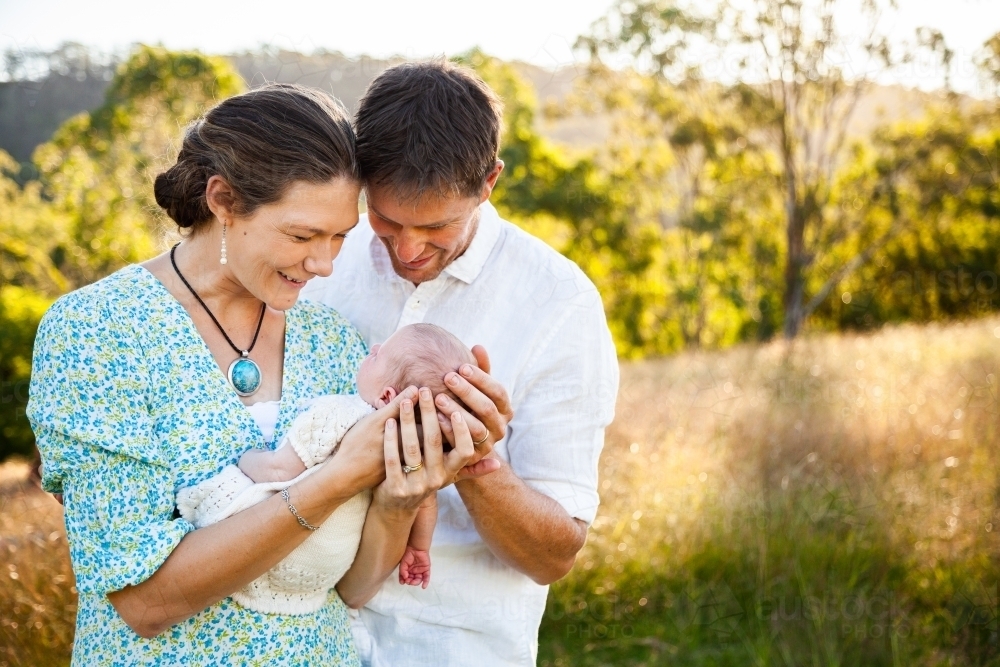 Parents holding their new baby outside on their farm - Australian Stock Image