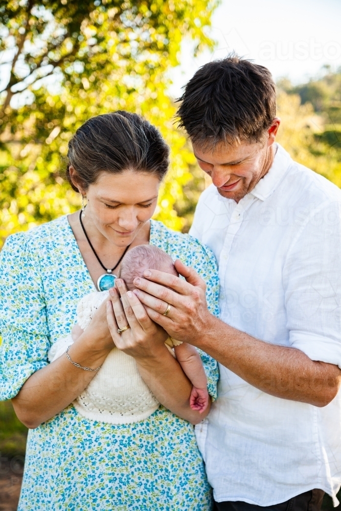 Parents holding their new baby outside on their farm - Australian Stock Image