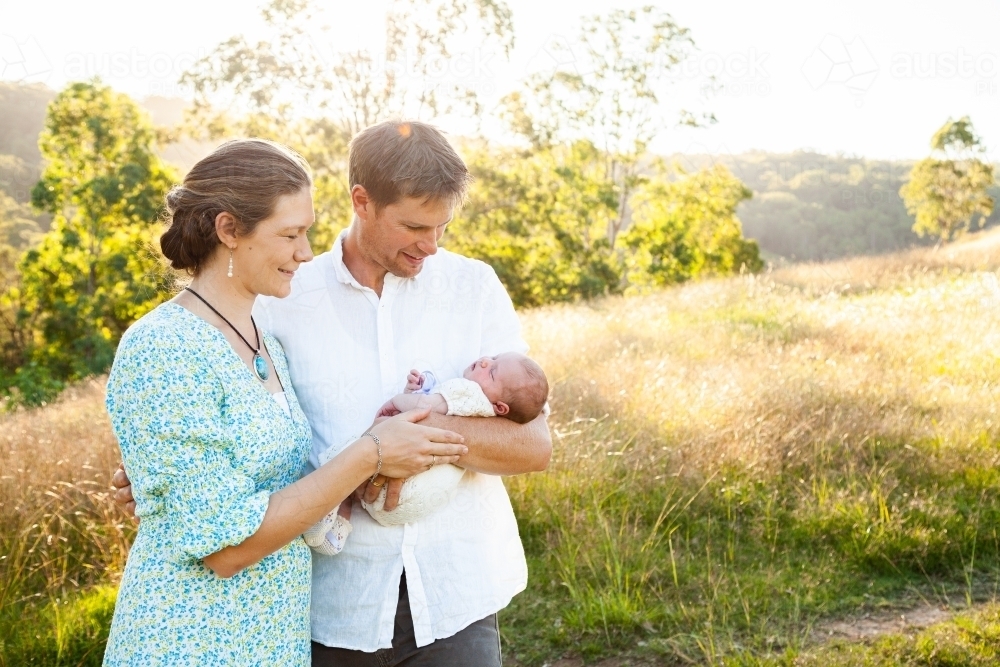 Parents holding their new baby outside on their farm - Australian Stock Image