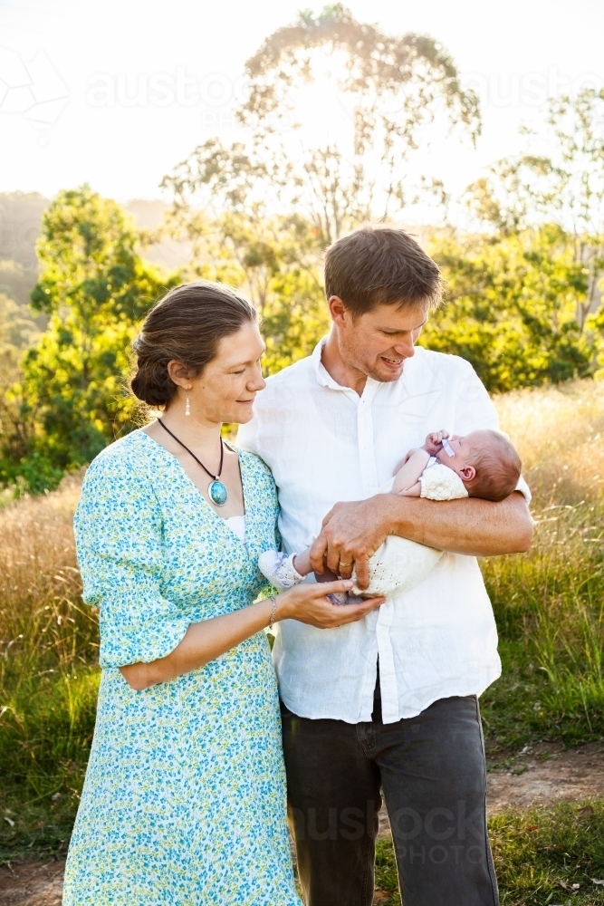 Parents holding their new baby outside on their farm - Australian Stock Image