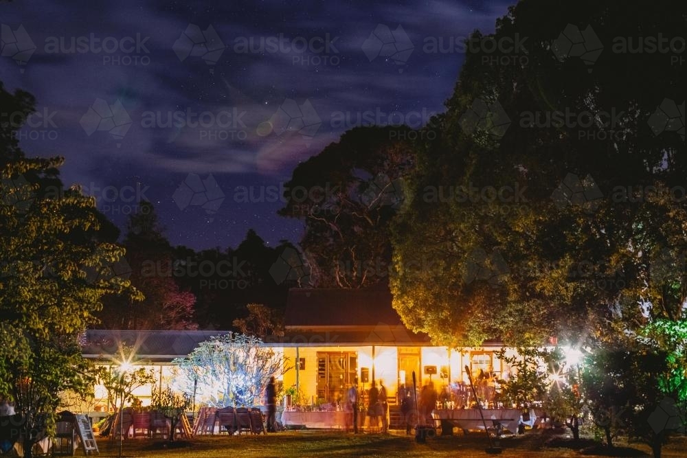 Party at Night in house surrounded by trees - Australian Stock Image