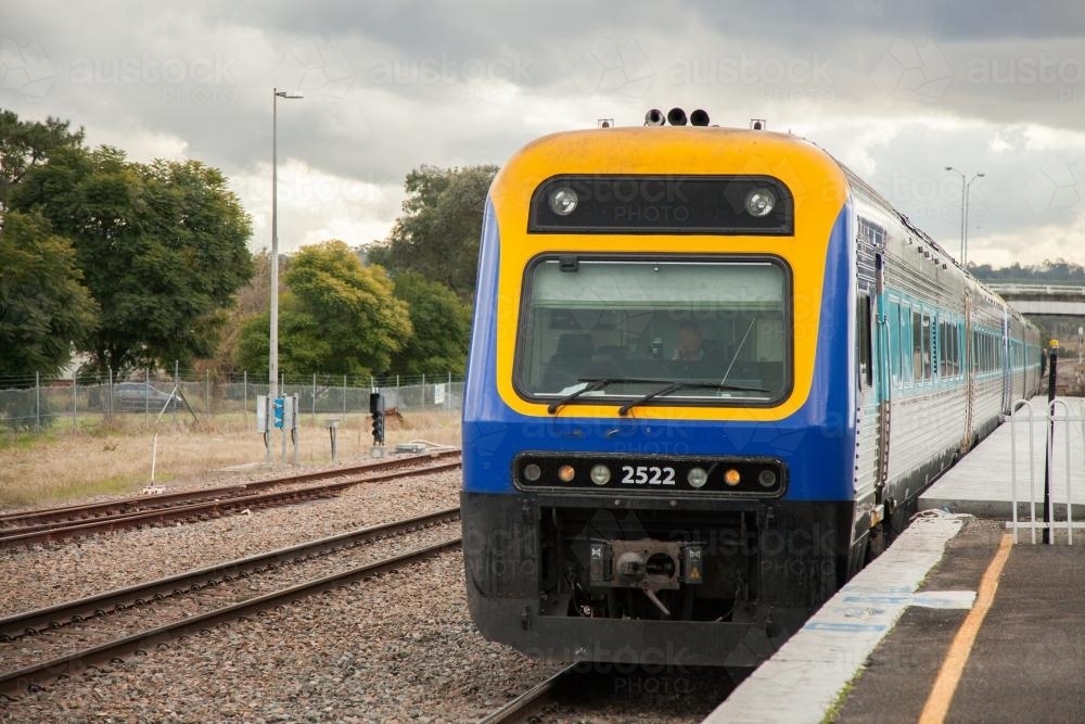 Passenger train approaching the platform at a train station - Australian Stock Image