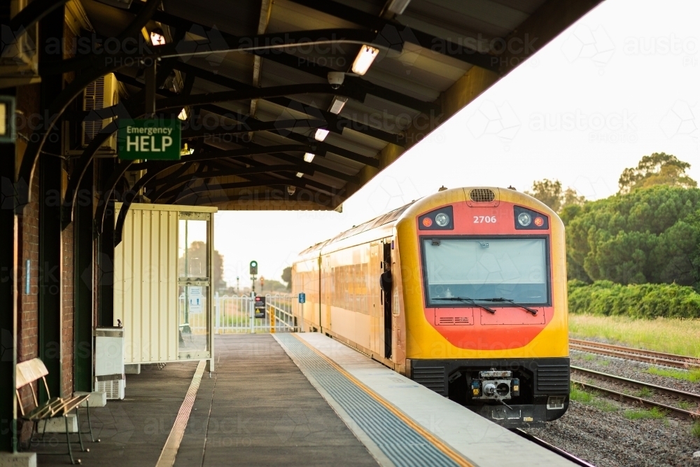 Passenger train pulling away from small country train station - Australian Stock Image