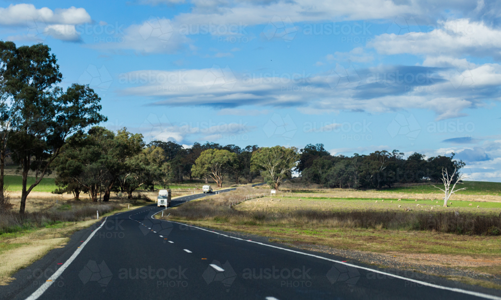 Image of Passenger view down bend in highway road through farmland ...