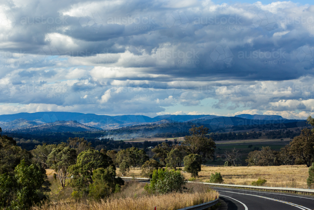 Image of Passenger view down bend in highway road through farmland ...