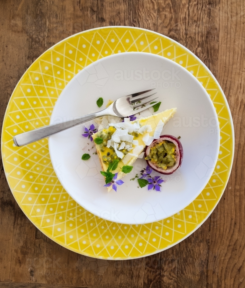 Passionfruit cheesecake with flowers and coconut - Australian Stock Image
