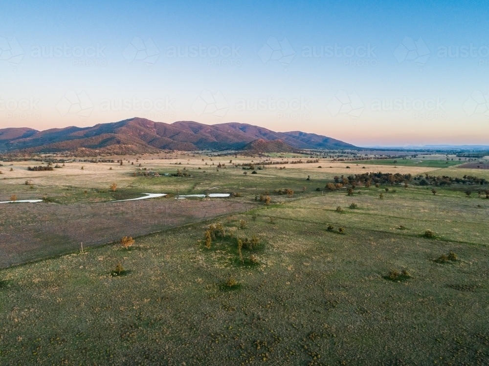 Pastoral farm landscape at dusk with hills on horizon in rural NSW - Australian Stock Image