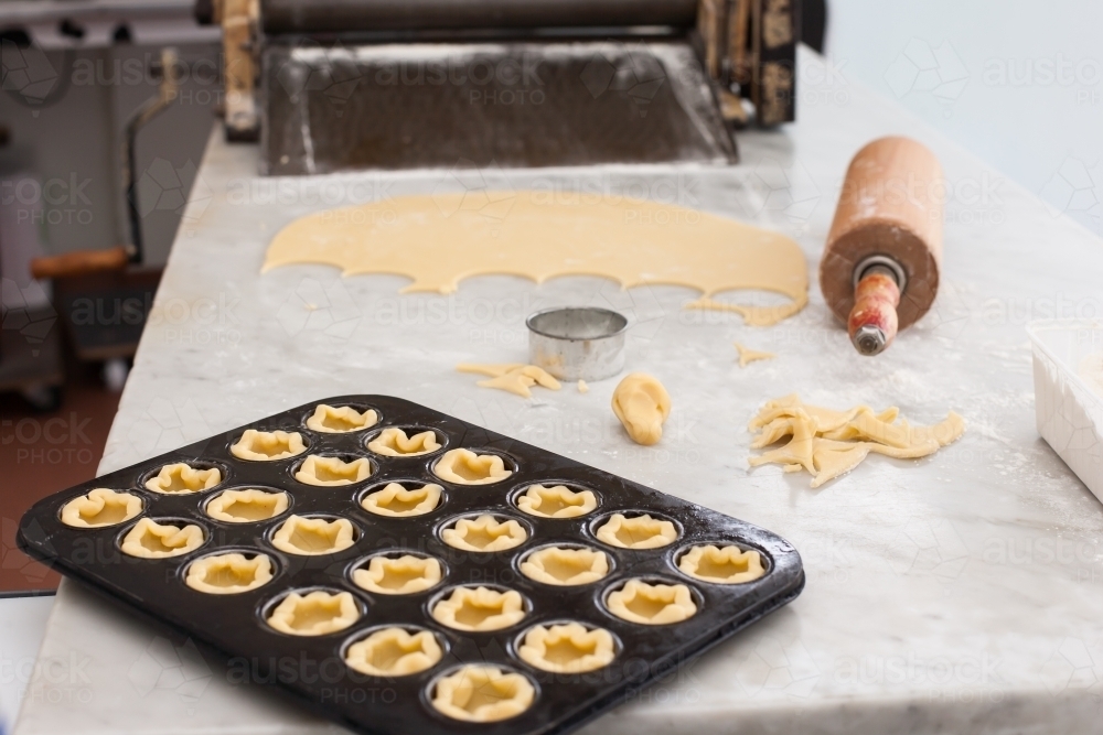 Pastry in a baking tray with rolling pin & dough - Australian Stock Image