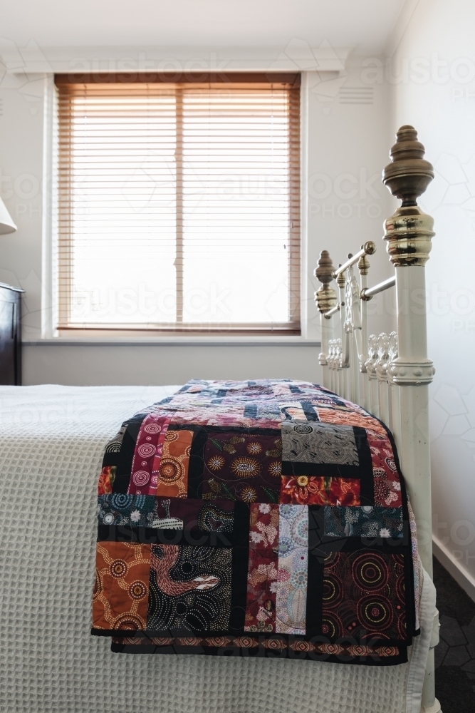 Patchword quilt details on a brass bed - Australian Stock Image